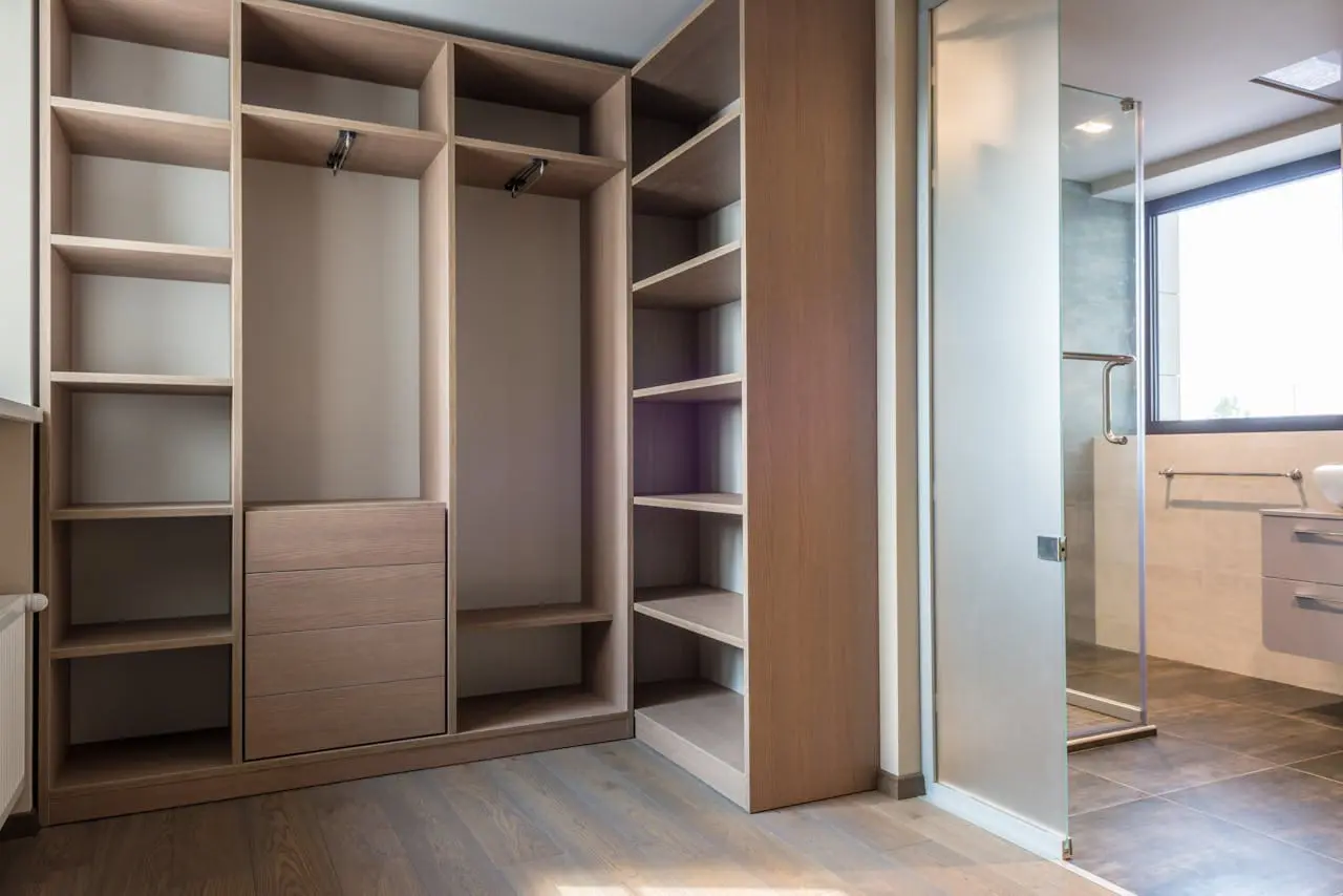 Spacious walk-in closet with wooden shelves and minimalist style.